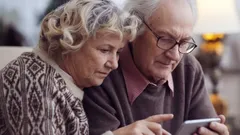 Senioři společně používají tablet, technologie pro starší generaci